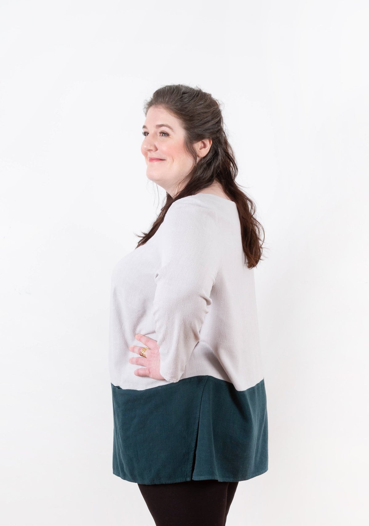 Three-quarter side view of Uniform Tunic showing hem curve and soft sleeve drape.