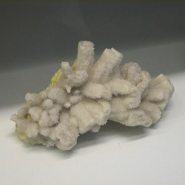 Pale cream and yellow mineral specimen with clustered crystalline formations