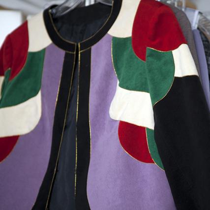 Vintage suede jacket with colorblock design in red, green, purple, cream, and black panels on hanger with gold zipper