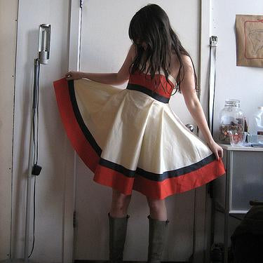 Colorblocked Kat dress with coral strapless bodice, ivory and gray skirt with pleated panels and black trim details
