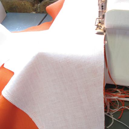White and orange linen top at serger finishing a seam