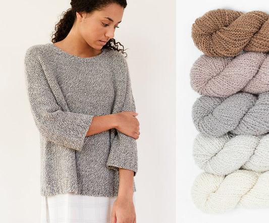 Julie Hoover Addison sweater in gray marled yarn beside Woolfolk Flette boucle skeins in tan, gray, light gray, and cream