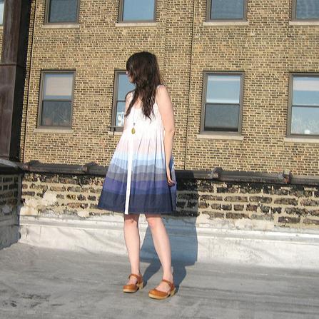 Sleeveless A-line dress with pink, lavender, and navy ombre dip-dye, worn with cognac sandals against a brick building
