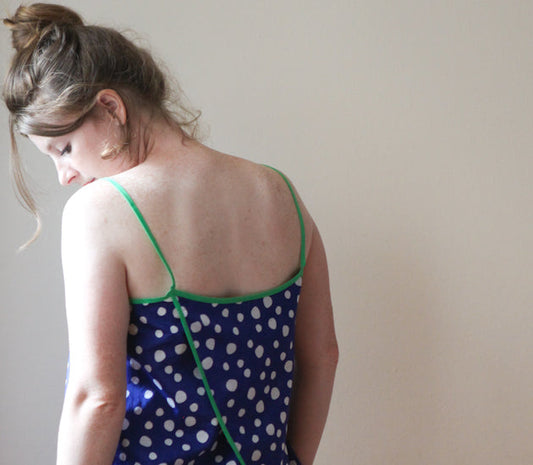 Back view of Lakeside Pajamas camisole in dark navy cotton voile with white polka dots and green bias binding straps