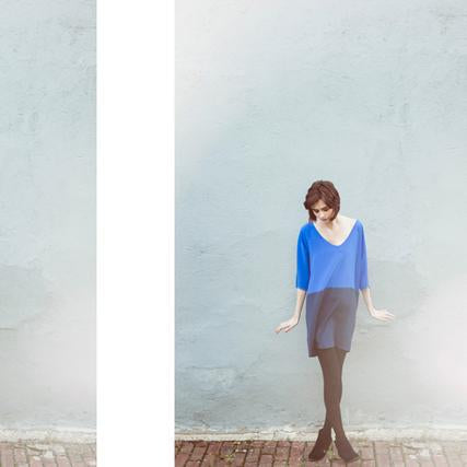 V-neck oversized shift dress in colorblock cobalt and navy crepe de chine with black boots and tights against seafoam wall