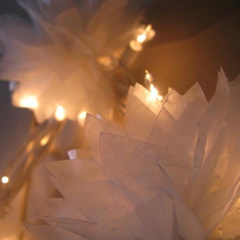 White paper luminaries with warm string lights, soft focus holiday decoration