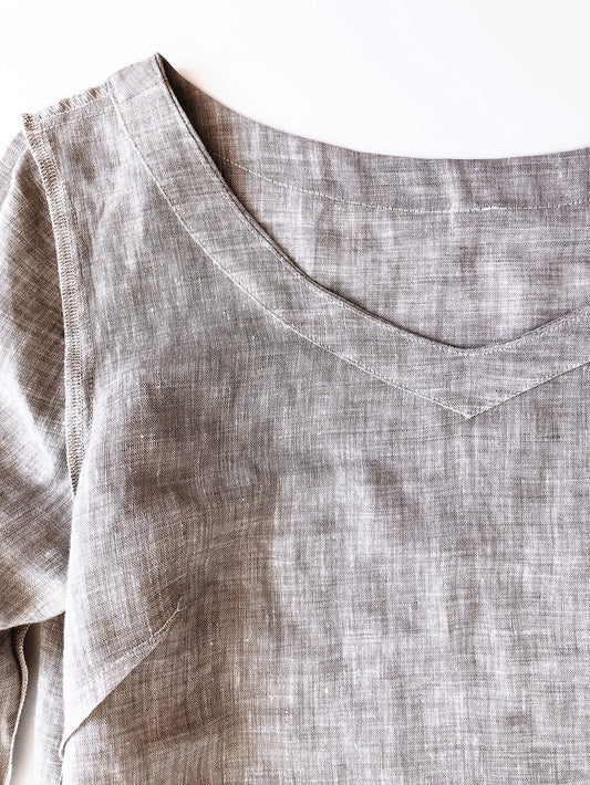 Uniform Tunic inside out showing V-neckline facing stitched down in natural linen, with visible seam allowances