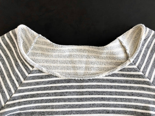 Linden Sweatshirt in gray and white stripe fleece showing rolled neckline construction detail on black background