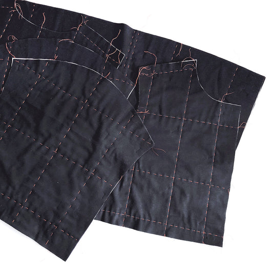 Hacked Tamarack Jacket black fabric pieces sandwiched and basted with contrasting thread to mark straight-line quilting grid
