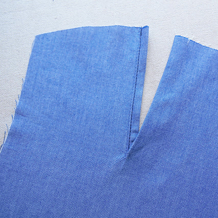Blue chambray Archer Button-Up sleeve with an inserted sleeve placket, showing stitching along the placket opening