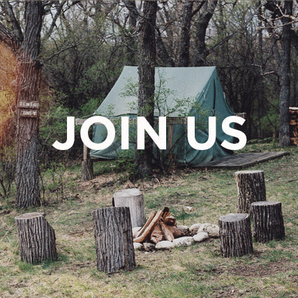 Camp Workroom Social JOIN US announcement with green tent and fire pit surrounded by tree stumps in wooded setting