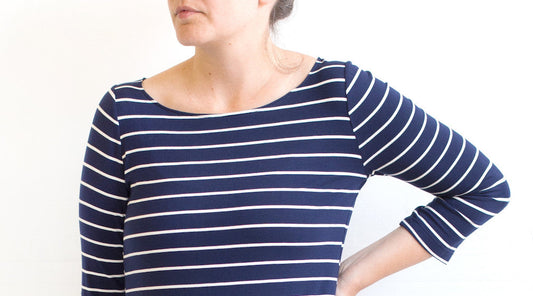 Lark Tee in navy and cream striped bamboo knit with three-quarter sleeves and boatneck neckline, worn by a woman