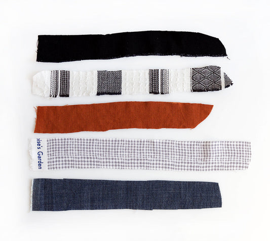 Five fabric swatches on white: black denim, black and white woven geometric, rust linen, gray and white check, and dark denim