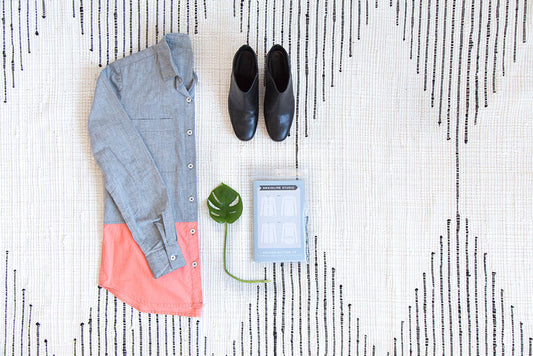 Archer Button Up in chambray with coral colorblock hem, black boots and Grainline Studio pattern envelope on a striped rug