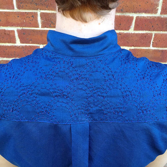 Back view of Archer Button-Up Shirt in royal blue with sashiko scallop embroidery across the yoke and turtleneck collar