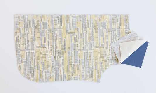 Tamarack Jacket quilt sandwich layers: yellow and gray print outer shell, batting, and blue lining fabric for assembly