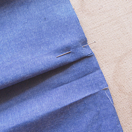 Blue chambray Archer Button-Up center back pleat pinned and pressed, showing pleat preparation before yoke attachment