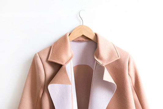 Yates Coat in blush wool on wooden hanger, open front showing notched collar with fusible interfacing on wrong side