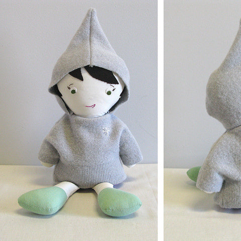 Handmade fabric doll with black bob, pointed gray knit hood and body, and green fabric feet shown from front and back