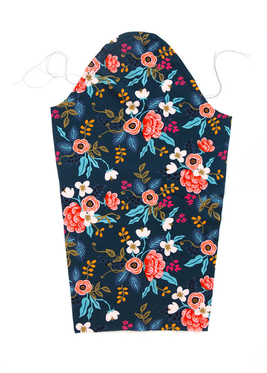 Farrow Dress sleeve with basting stitches at sleeve cap in navy floral print with coral roses, white flowers, and teal leaves
