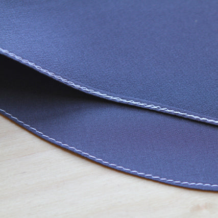 Navy silk crepe de chine with rolled hem and contrasting stitching on wood, demonstrating a rolled hem technique