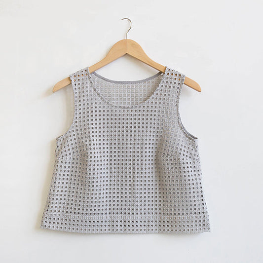 Cropped Willow Tank in dove gray square eyelet with scoop neck and deep hem, displayed on a wooden hanger against white wall