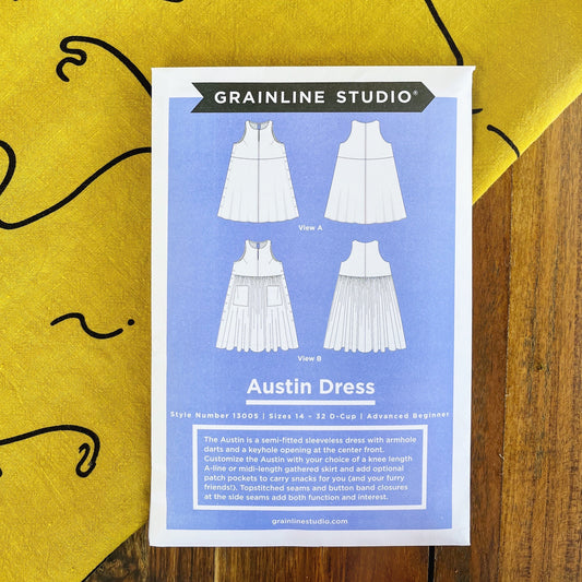 Grainline Studio Austin Dress sewing pattern envelope sizes 14–32 with View A and View B line drawings on yellow linen