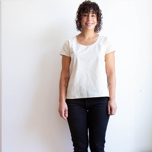 Scout Tee muslin in natural cotton with short sleeves and scoop neckline, paired with black pants