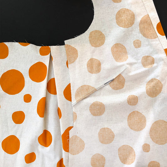 Augusta Shirt & Dress pattern pieces in cream linen with orange polka dots showing dart and back pleat construction details