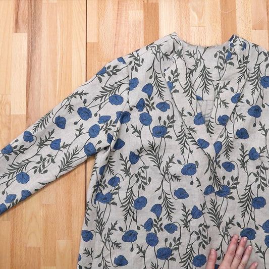 Augusta Shirt & Dress in blue poppy and vine print linen, long sleeve laid flat on wood table during collar assembly