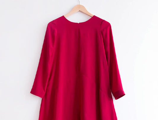 Farrow Dress in red silk crepe de chine on wooden hanger, sewn without inseam pockets