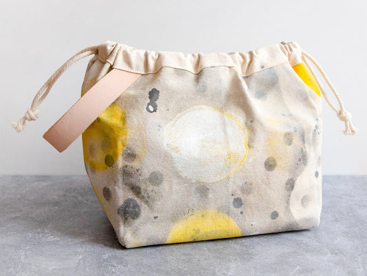 Field Bag in Artist Series fabric by Bob Bechtol with yellow and gray painted circles on natural canvas with leather handle