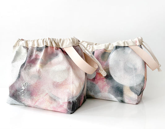 Two Field Bags in Artist Series fabric by Bob Bechtol in pink, gray, and cream abstract print with natural leather handles