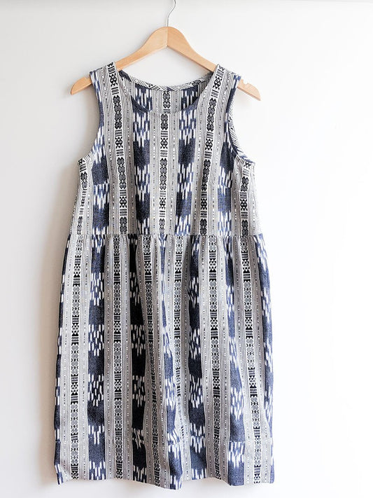 Willow Tank Dress hack in navy and white ikat print with gathered waist and skirt, on wooden hanger