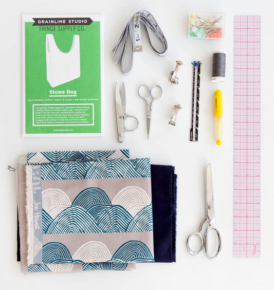 Stowe Bag pattern envelope with sewing tools and Jen Hewett wave-print fabric in teal and gray, plus navy solid