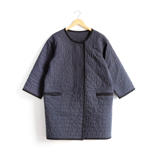 Modified Tamarack Jacket in charcoal quilted cotton, three-quarter sleeves, round neckline, welt pockets, and black binding