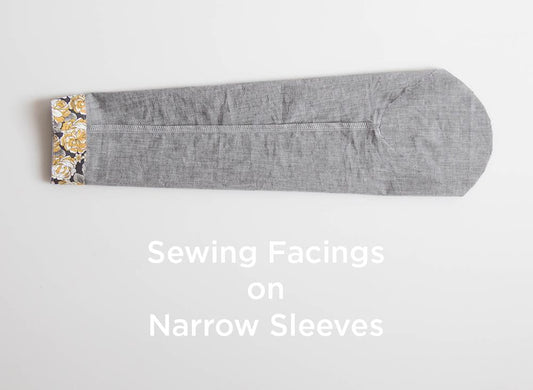 Sewing Facings on Narrow Sleeves tutorial: gray fabric sleeve with yellow floral facing sewn at cuff