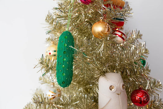 Grainline Studio felt Christmas pickle ornament with green sequins on gold tinsel tree, with snowy owl ornament and baubles