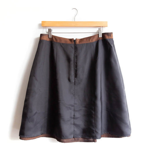 Reed Skirt shown inside out, revealing charcoal lining, brown textured waistband and hem trim, and center back zipper
