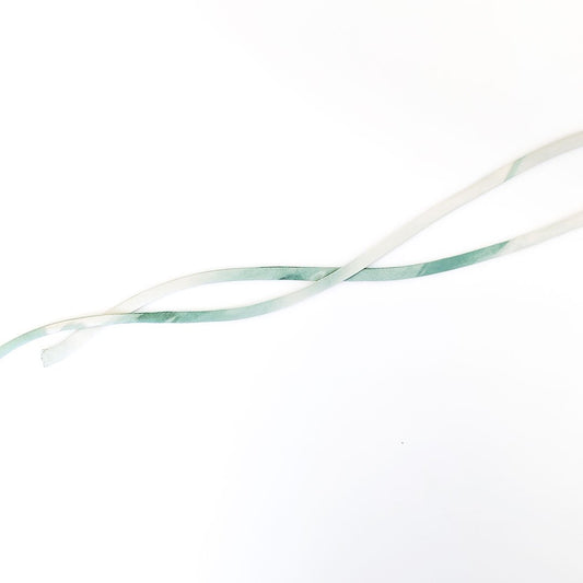 Narrow fabric tubes in cream and sage green showing turned spaghetti straps made using the rouleau method on white background