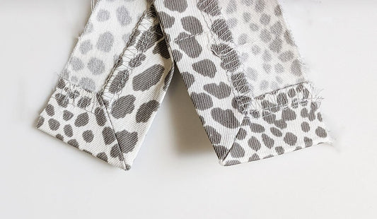 Wrong side of mitered fabric scraps in gray and white spotted print, folded at 45-degree angles