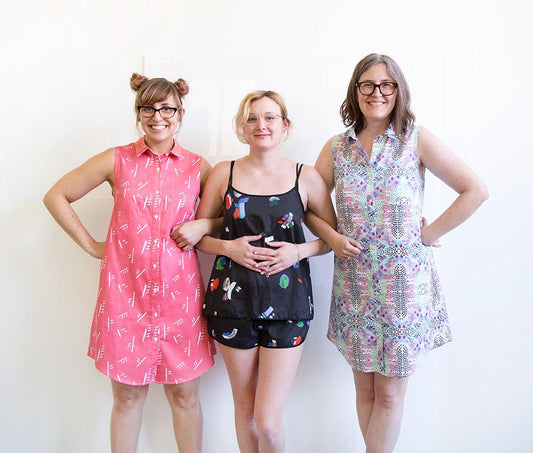 Three people in Grainline makes: pink Alder Shirtdress, black print Lakeside Pajamas, and purple geometric print Alder