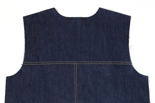 Thayer Jacket back piece in dark denim showing center back seam, horizontal yoke seam, and gold topstitching detail