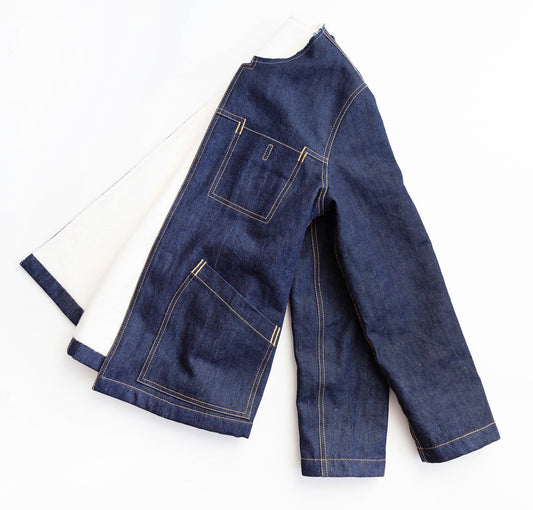Thayer Jacket in dark indigo denim with cream lining, showing open jacket with topstitched patch pockets and hem details
