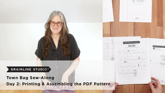 Grainline Studio Town Bag Sew-Along Day 2 thumbnail with printed PDF pattern pages and numbered assembly grid on wood surface