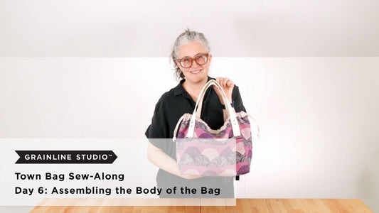 Grainline Studio Town Bag Sew-Along Day 6 thumbnail with Jen Beeman holding pink and purple print Town Bag with cream handles