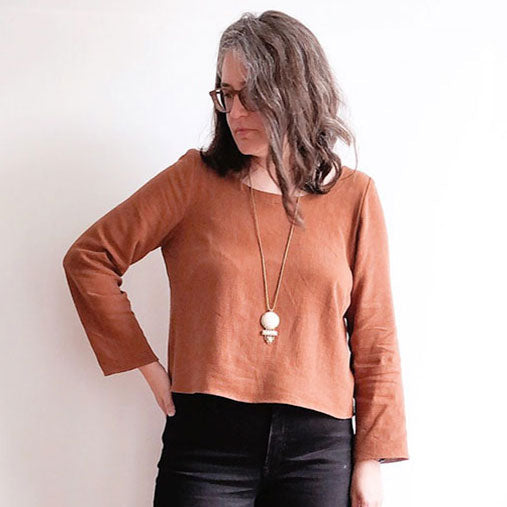 Uniform Tunic modified into a cropped Uniform Shirt in rust linen-rayon blend, long sleeves, pendant necklace, dark jeans