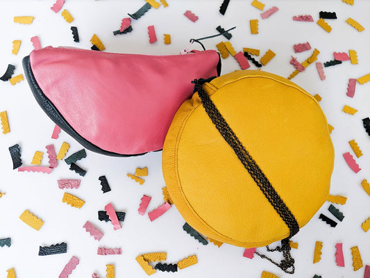 Watermelon and lemon shaped leather zippered pouches, lemon with black chain strap, leather confetti background