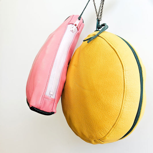 DIY leather fruit pouch tutorial: pink watermelon and yellow lemon pouches with chain straps, hanging on white