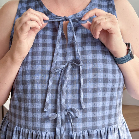 Close up of Austin Dress tie front bow variation in blue gingham showing three decorative bows at center front bodice